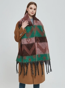 Detail of winter thick shawl with colorful geometric patterns and long fringe tassels