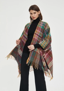 Detailed view of the zigzag knit pattern and dense fringe on a colorful shawl