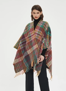 Close-up of knit shawl with colorful zigzag patterns, fringe hem, and ethnic style