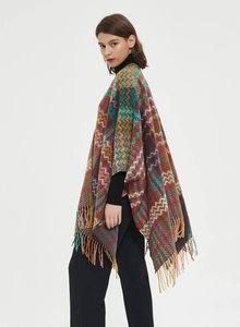 Close-up of zigzag geometric knit pattern and long fringe details on winter shawl