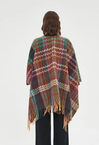 Detailed view of colorful knit shawl featuring geometric patterns and long fringe tassels