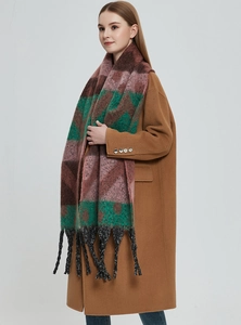 Detail of a thick winter scarf with colorful plaid patterns and woven fringe tassels