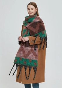 Detail of winter knit shawl with geometric patterns and thick black tassel trim