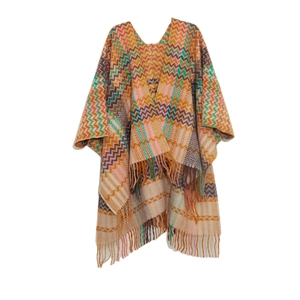 Macro shot of knitted shawl featuring colorful zigzag patterns and long fringe details