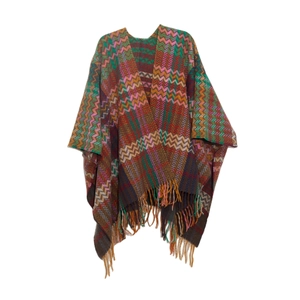 Detail of bohemian knit shawl featuring colorful geometric patterns and long fringe edges