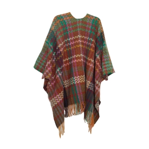 Detail of colorful knitted poncho with bohemian wave pattern and soft white tassels