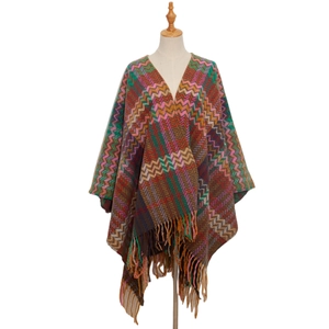 Detail of bohemian knit shawl with colorful wave patterns and long tassel fringe edges