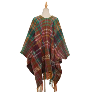 Detail of colorful zigzag knit poncho showing bohemian ethnic patterns and soft tassel fringe