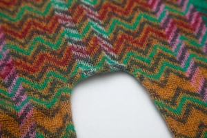 Close-up of zigzag knit texture showing colorful wave patterns on thick woolen shawl