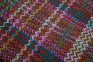 Macro shot of chevron knit fabric texture with vibrant brown orange and pink waves