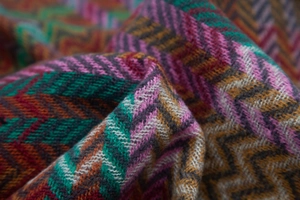 Close-up of bohemian zigzag knit texture and colorful patterns on a soft winter shawl