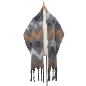 Close-up of thick winter scarf with heart jacquard patterns and long tassel fringe