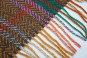 Detailed close-up of ethnic style striped knit shawl with soft fringed edges