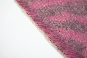 Detail of pink and grey zebra pattern knit scarf with soft decorative fringe edges