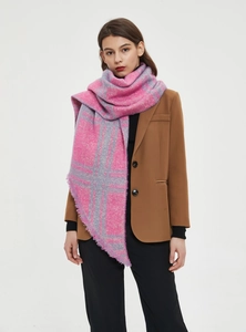 Detalle de bufanda de cuadros rosa y gris con flecos sobre un conjunto con blazer café