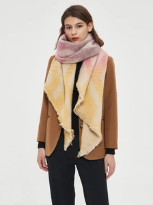 Detail of soft chunky knit scarf with colorful plaid pattern and long tassel fringes
