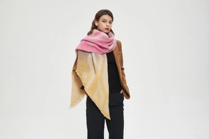 Close-up of thick geometric knit shawl with pink and yellow color block and frayed edges