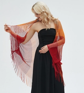 Detail of knit gradient shawl with hollow mesh pattern and long red orange fringes