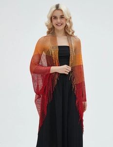 Detail of thin mesh knit shawl featuring orange-red gradient colors and fringe trim