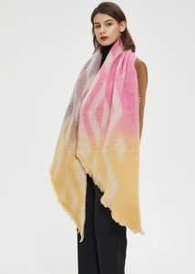 Detail of soft knit shawl with geometric gradient pattern and fringe tassels for winter
