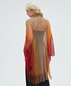 Detail of hollow knit shawl with orange gradient mesh and long fringe tassels