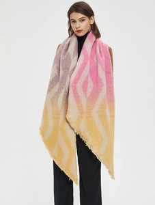 Close-up of geometric gradient thick shawl scarf with fringe edges worn by model