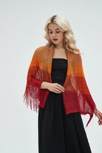 Macro view of warm gradient knit shawl with hollow mesh pattern and long fringed tassels
