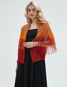 Detail of hollow-out mesh knit shawl with orange-red gradient and tassel trim finish