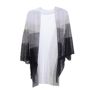 Detail of knit gradient shawl featuring intricate openwork patterns and long tassels