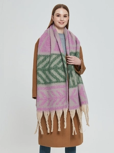 Detail of chunky knit scarf with purple and green leaf pattern and thick tassels