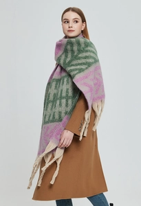 Detailed view of thick knit scarf with leaf jacquard pattern and long fringe tassels