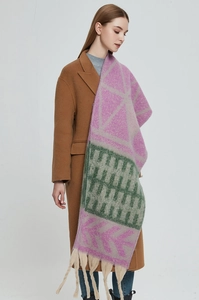 Detailed view of thick knit scarf with leaf jacquard pattern and long tassels on a model
