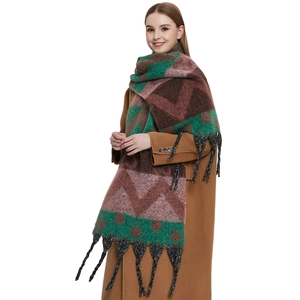 Thick winter scarf with colorful geometric patterns and long tassels on a caramel coat