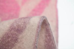 Detailed close-up of thick geometric striped knit scarf fabric with soft fuzzy texture