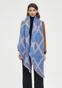 Détail d'une écharpe à carreaux bleu et rose avec maille épaisse et franges