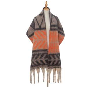 Close-up of thick knitted shawl with geometric leaf pattern and chunky tassel details