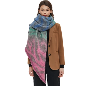 Colorful striped knit scarf with fringes worn over a brown blazer in a studio shot