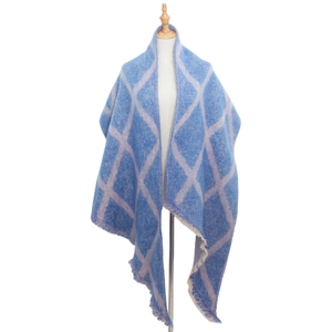 Détail d'une écharpe à carreaux bleus et blancs avec franges et matière épaisse