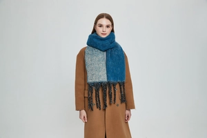 Detailed view of thick winter scarf with deep peacock blue gradient and chunky fringe