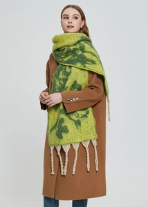 Detailed close-up of thick winter scarf featuring green floral patterns and beige fringes
