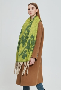 Detail of green floral jacquard scarf with thick fringes and soft mohair-like texture