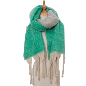 Detail of chunky knit scarf showing thick yarn texture and long twisted tassels in green