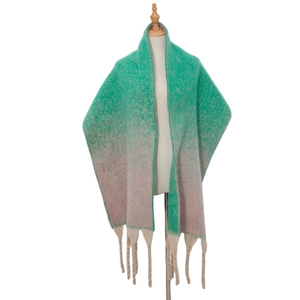 Close-up of thick gradient knit scarf with chunky tassels in green and pink tones