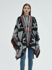 Dettaglio dello scialle in maglia geometrica con motivo jacquard etnico e blocchi di colore