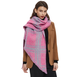 Bufanda gruesa de cuadros rosa y gris con flecos mostrada en modelo para otoño invierno