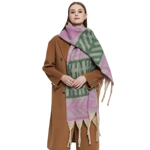 Thick knit shawl with colorful geometric patterns and long tassels on model
