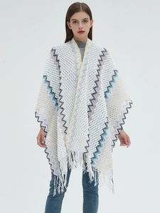 Detail of white knit shawl showing colorful zigzag patterns and fringe trim edges