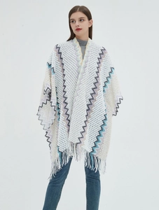 Detail of bohemian knit shawl with zigzag jacquard patterns and elegant fringe tassels