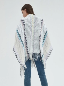 Detail of bohemian knitted shawl with geometric patterns and fringe tassels on the back