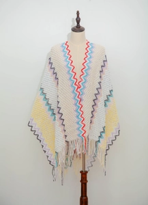 Detail of bohemian knit shawl featuring colorful zigzag patterns and long fringes